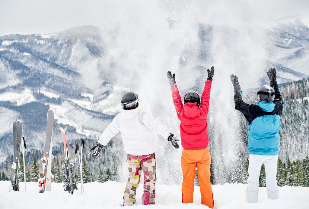 Skiers team having fun in snowy mountains.